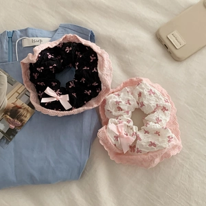 Détail de chouchous en dentelle noir et blanc avec nœuds roses et motifs floraux