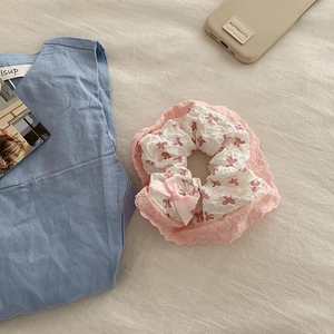 Gros plan détaillé sur chouchou en dentelle rose avec motifs nœuds sur tissu doux