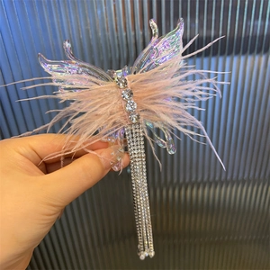 Detail of pink feather butterfly hair clip with crystal rhinestone tassels and acrylic wings