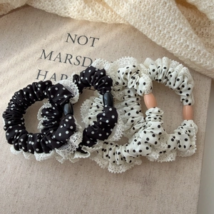 Détail de chouchous à pois avec dentelle blanche et perles centrales élégantes