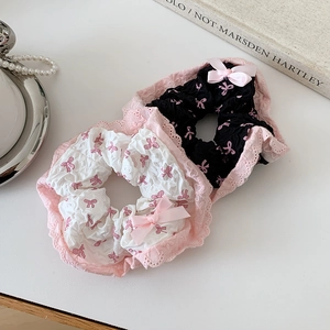Détail de chouchous en dentelle noir et blanc avec motifs et nœuds en satin rose doux