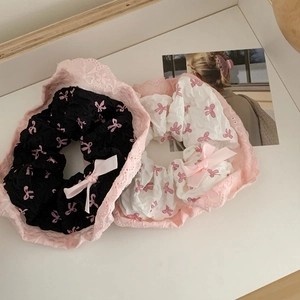 Détail de chouchous à fleurs roses avec bordure en dentelle et nœuds délicats