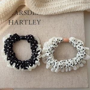 Détail de chouchous à pois avec bordure en dentelle blanche délicate en noir et blanc