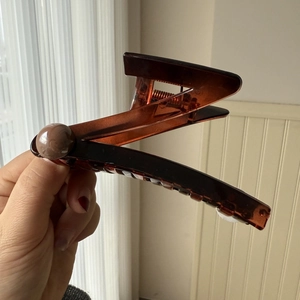 Detail of a large dark brown translucent hair claw clip with geometric folding design