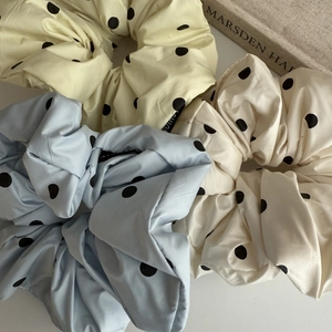 Détail de chouchous géants en satin français à pois noirs présentés en trois couleurs