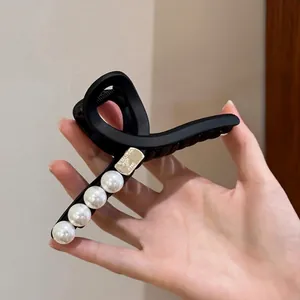 Eleganter schwarzer matter Haarclip mit weißen Perlen und goldenem Metallakzent