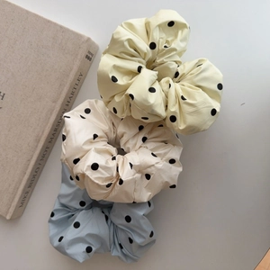 Détails des chouchous en soie jaune pâle, crème et bleu clair à pois noirs élégants