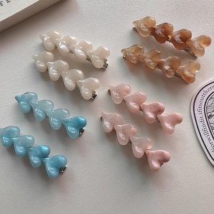 Detailed macro view of colorful jelly-textured acrylic heart-shaped hair clips set