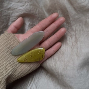 Detail of elegant acetate hair clips in translucent grey-purple and yellow with gold glitter