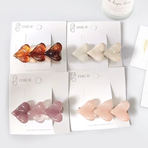 Barrettes à cheveux élégantes en forme de cœur, tons ambre et crème sur présentoir