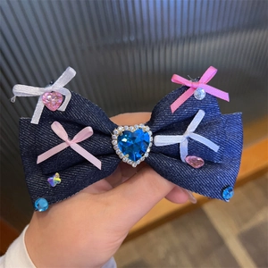 Detail of blue denim bow hair clip with large heart rhinestone and colorful crystals