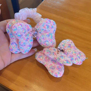 Détail de l'ensemble d'accessoires cheveux avec nœuds rose pailletés et cristaux