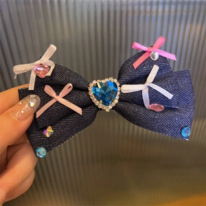 Macro shot of denim bow hair clip with a blue heart rhinestone and Y2K aesthetic detail
