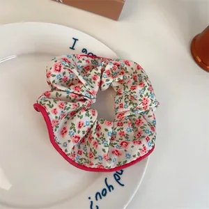 Chouchou à fleurs rose avec bordure rouge posé sur une assiette blanche élégante