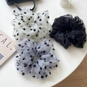 Set di tre elastici per capelli in tulle a pois su una scrivania dallo stile minimalista