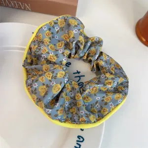Vue macro détaillée d'un chouchou bleu à fleurs avec des motifs smiley jaunes sur une assiette