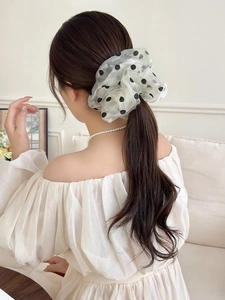 Vista dettagliata dell'elastico scrunchie a pois in rete su una coda di cavallo