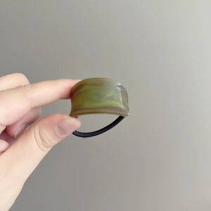 Elastic hair tie featuring a green marble pattern acrylic cylinder decorative bead