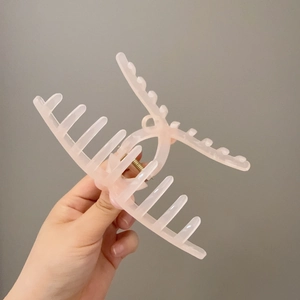 Pink matte resin wheat-ear hair claw clip for elegant women styling on grey background