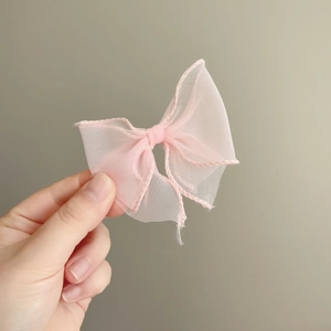 Handmade pink tulle bow hair clip with decorative corded edge for a fairy-inspired look
