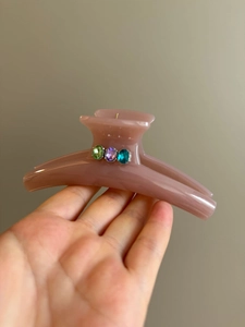 Detail of large matte pink ponytail hair claw clip with colorful oval gemstones