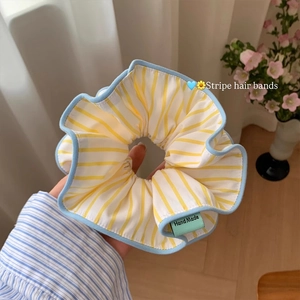 Detail of yellow striped oversized scrunchie with blue edging and handmade woven label