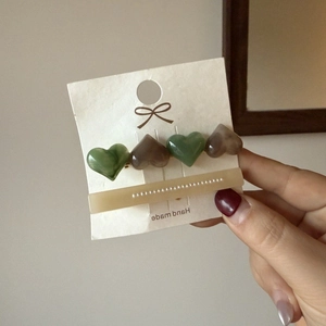 Detail view of a French hair clip set with resin hearts and inlaid miniature pearls