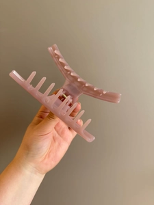 Detail of a large lotus pink resin hair claw clip for ponytail styling and updo hairstyles