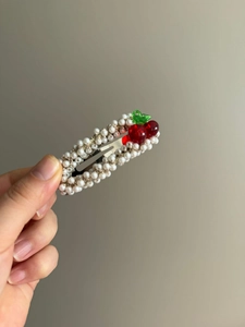 Détail de la barrette cerise avec perles blanches et perles rouges sur métal argenté