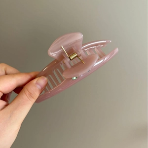 Sparkling rhinestone ponytail hair claw clip in dusty pink resin for elegant hairstyling