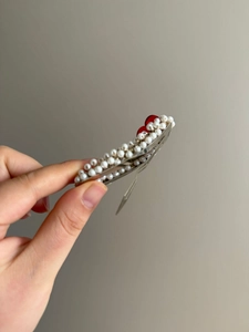Détail d'une pince à cheveux cerise avec perles blanches et accents rouges