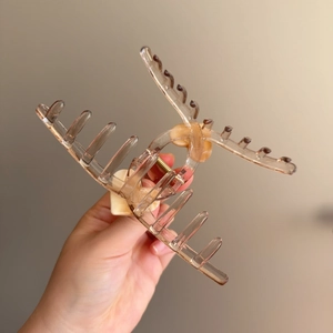 Handheld 13cm amber jelly hair claw clip with cream heart details and large grip
