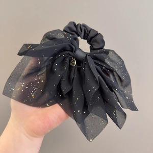 Détail de chouchou nœud en mousseline noire avec paillettes dorées et pendentif