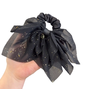 Chouchou élégant avec nœud noir, sequins dorés étincelants et pendentif en métal
