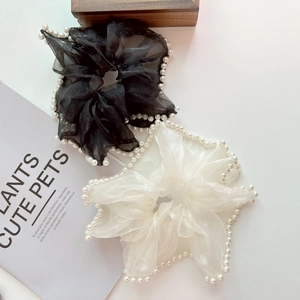 Détail de chouchous en organza noir et beige avec bords en perles élégantes et plis doux