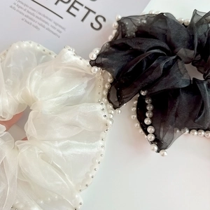 Gros plan de chouchous en organza noir et blanc avec bordures en perles élégantes