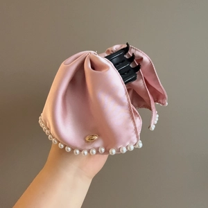 Pink satin ribbon hair claw clip with pearl trim and golden brand logo detail
