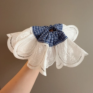 Detail of blue checkered hair scrunchie with layered white floral lace embroidery