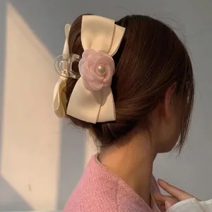 Pince à cheveux élégante avec grand nœud en résille, rose en tissu et perles sur un mannequin