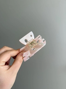 Vista dettagliata di una molletta per capelli a farfalla rosa semitrasparente in acetato