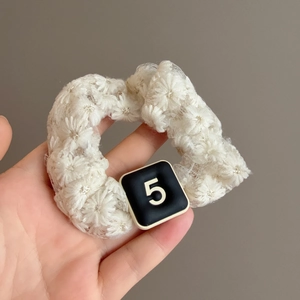 Elegant white lace scrunchie with daisy textures and black square number 5 charm