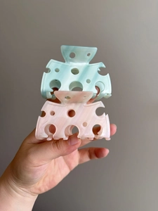 Dettaglio di fermagli per capelli a forma di formaggio in azzurro e rosa pastello