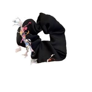 Elegant black satin scrunchie with colorful fringe trim and stylish ruched fabric texture