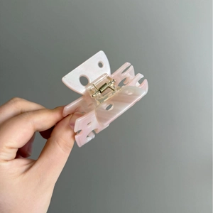 Pinza per capelli rosa marmorizzato con design a triangolo traforato per acconciature