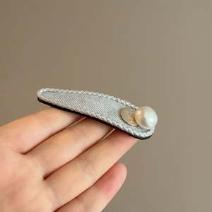 Chic vintage cross fabric hair clip in grey featuring a white pearl and gold love pendant