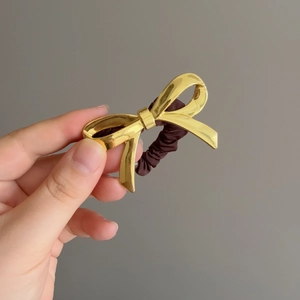 Elegante elastico per capelli con fiocco in metallo dorato lucido e finitura a specchio