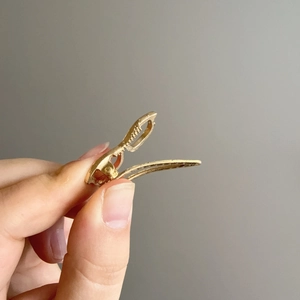 Barrette à cheveux minimaliste en métal doré avec design antidérapant tenue à la main