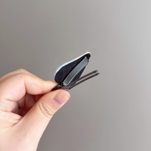 Detail view of the metal alligator clip base and black fabric lining on heart hair clip