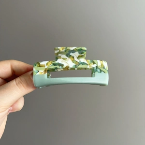 Handheld two-tone marble acetate hair claw clip with mint green hollow square design