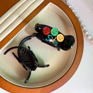 Detail von schwarzen Haarklammern mit Smileys auf einem Samt-Schmucktablett-Display